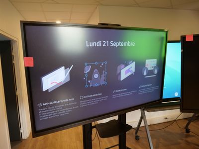 a large flat screen tv in a room with wooden floors