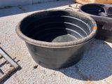 un grand pot noir posé par terre à côté d'autres objets