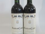 two bottles of wine sitting next to each other on a table