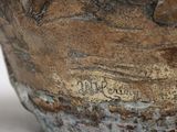 a close up of a vase on a white surface