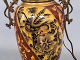 a gold vase with a dragon on it on a table