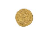 a close up of a gold coin on a white surface