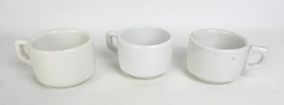 trois tasses à café blanches sont alignées sur une surface blanche