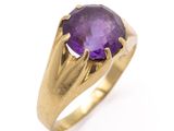 a close up of a gold ring with a purple stone
