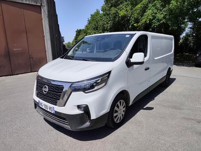 la camionnette blanche est garée devant un bâtiment