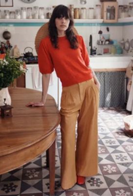 a woman that is standing in a kitchen with a table