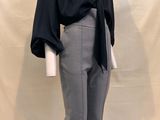 a mannequin wearing a black top and grey pants