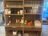 a tall wooden shelf with many glasses on it
