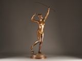 bronze statue of a woman holding a golf club on a marble base
