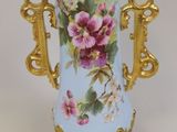 un vase bleu orné de fleurs roses, posé sur un fond blanc