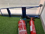 two red fire extinguisors sitting on the grass outside of a window