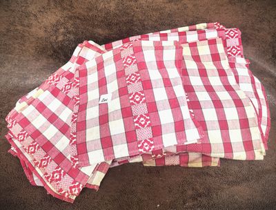 three pieces of pink and white checkered cloth on a brown surface