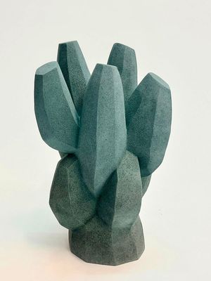 une sculpture verte représentant un cactus sur un fond blanc