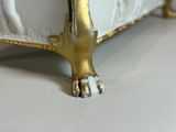 a white bed with a gold foot and foot rest