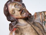 statue of a man holding a piece of wood in his right hand