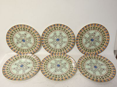six assiettes ornées de motifs, posées sur une surface blanche