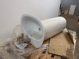 un urinoir blanc posé sur une palette dans un entrepôt