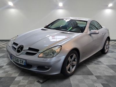une photo d'une Mercedes SLK argentée garée dans un garage