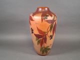 une image représentant un vase orné de feuilles et de baies