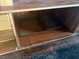 une armoire en bois dont la porte est ouverte et repose sur le sol
