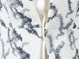 a close up of a white jacket with black and white flowers on it