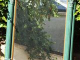 un miroir posé par terre devant des buissons