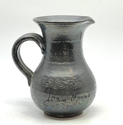 un pichet noir avec une inscription sur fond blanc