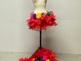 un mannequin vêtu d'une robe rouge ornée de fleurs colorées