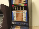 a slot machine that is sitting next to a chair