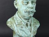 a statue of a man with a mustache on a black background