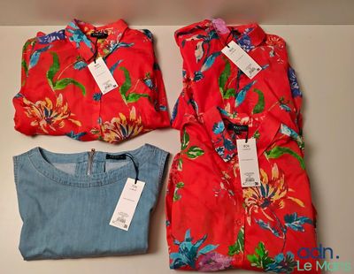 trois chemises et un jean posés sur une table