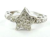 un gros plan d'une bague en forme d'étoile sertie de diamants sur fond blanc