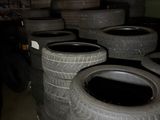 several tires are stacked up in a room with a wall in the background
