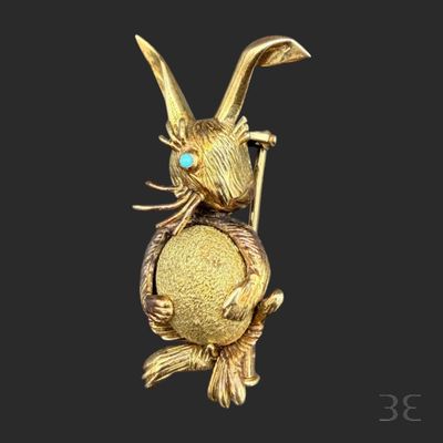 an image of a gold rabbit with a blue eye sitting on top of a tree branch