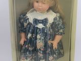 une poupée dans une boîte, vêtue d'une robe bleue