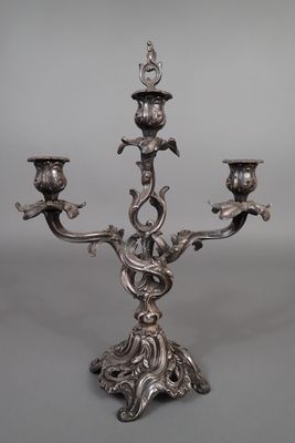 a silver plated candelab with three candles on a stand