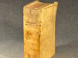 an old book sitting on top of a table on a gray surface