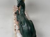 statue of a bull laying down on a marble base