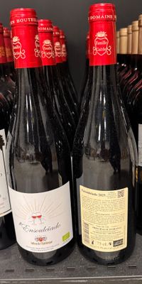 plusieurs bouteilles de vin sont alignées sur une étagère dans un magasin