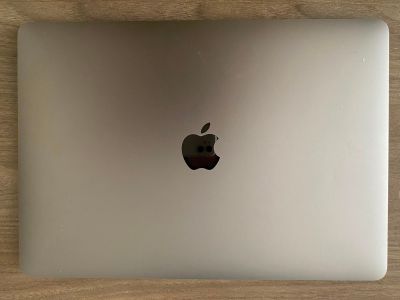 un ordinateur portable Apple posé sur une table en bois
