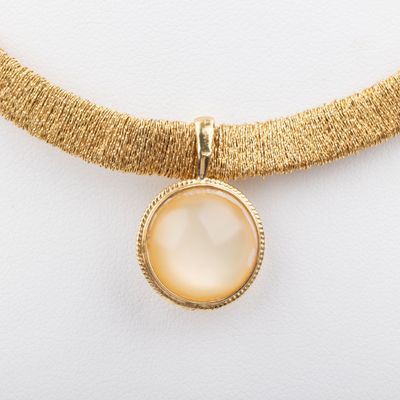 un collier en or orné d'un pendentif en nacre