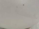 a white bowl on a white plate with a black cord