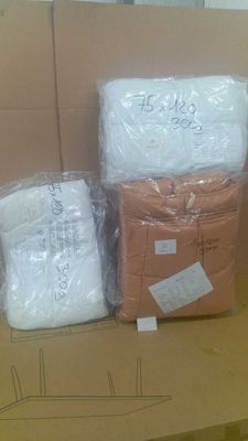 trois cartons contenant des couvertures blanches posés sur un carton