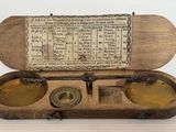 une vieille boîte en bois contenant deux récipients en laiton