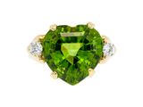 un gros plan d'une bague verte en forme de cœur sertie de diamants
