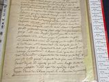an old document with writing on it sitting on a table