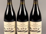 trois bouteilles de vin sont alignées sur une table