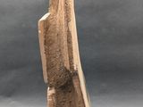 carved stone sculpture of a woman ' s head on a gray background