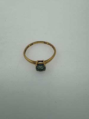 a close up of a gold ring with a green stone
