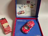 une petite voiture rouge dans une boîte rouge, à côté d'autres petites voitures